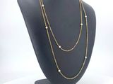 a close up of a necklace on a mannequin with a white background