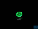 a close up of a green diamond on a black surface
