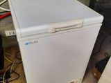 a small white refrigerator sitting on the floor in a room