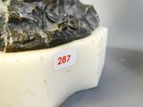 une statue représentant un homme assis sur un rocher
