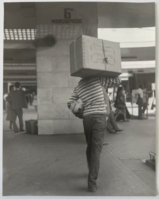 photographie en noir et blanc d'un homme portant une boîte sur la tête