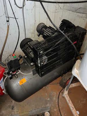 un petit compresseur d'air posé dans un coin de la pièce