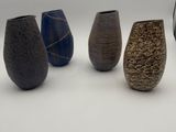 five vases that are lined up on a white surface