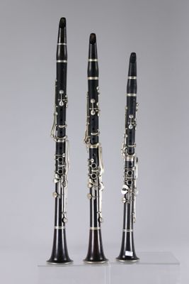 three clarinets are lined up in a row on a white surface