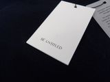 a white tag that says be entitled on a black shirt