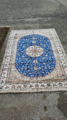 un tapis bleu et blanc posé par terre à côté d'une borne d'incendie