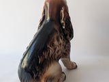a figurine of a dog sitting on a white surface