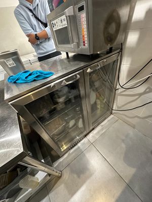 un homme debout dans une cuisine, devant un micro-ondes