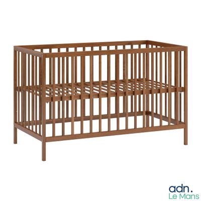 Le lit de bébé est en bois et possède un cadre en métal.