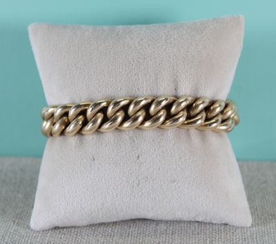 gros plan d'un bracelet en chaîne en or sur un oreiller