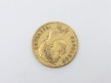 a close up of a gold coin on a white surface