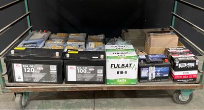 many boxes of batteries on a cart in the garage