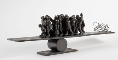 une sculpture représentant un groupe de personnes sur une balançoire à bascule