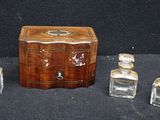 a small wooden box with three bottles of perfume on a table
