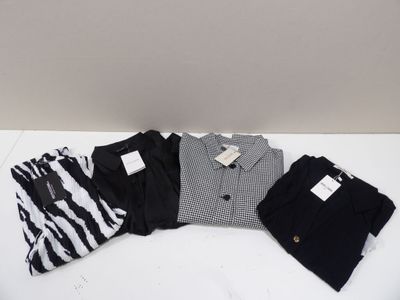 trois paires de chemises et de pantalons noirs et blancs posées sur une surface blanche
