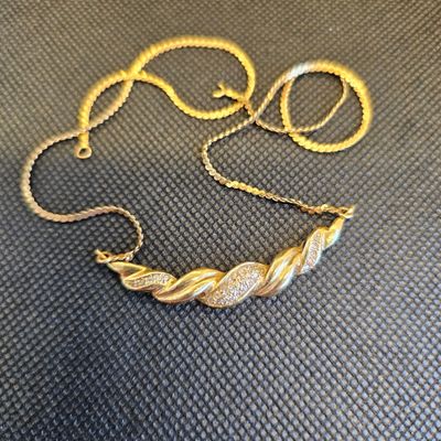 gros plan d'un collier en or sur une surface noire
