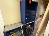 une photo d'une pièce avec une armoire bleue et une boîte à outils rouge
