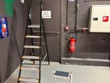 une photo d'une pièce avec une échelle et un extincteur