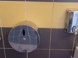 des toilettes et un lavabo dans une salle de bains carrelée de jaune et de gris