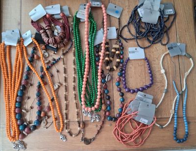 de nombreux colliers et bracelets exposés sur une table