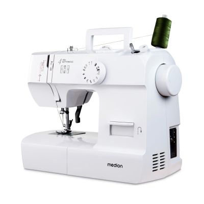 a white sewing machine with a spool of thread on it