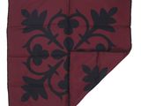 a close up of a red and black handkerchief with black flowers on it