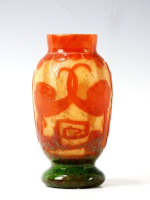 an orange vase with a face on it sitting on a table