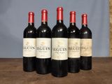 four bottles of wine are lined up on a wooden table