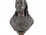 a bronze bust of a man with long hair and beard