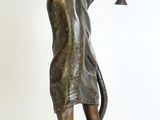 statue en bronze représentant un homme tenant une trompette, posée sur un socle en marbre