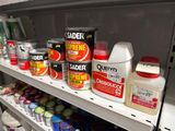 many cans of paint on a shelf in a store