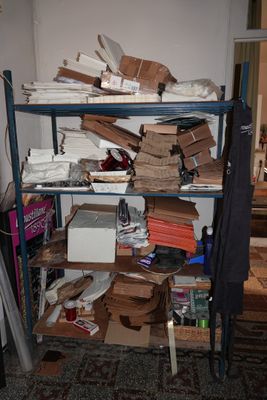 a shelf full of boxes and other items in a room
