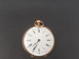 une montre de poche ancienne avec des chiffres romains sur fond noir