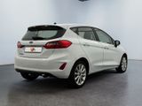 the rear end of a white ford fiesta parked in a garage