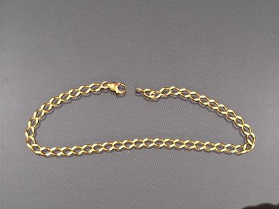 a close up of a gold chain bracelet on a table