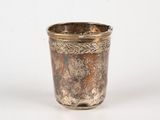 a silver cup that is sitting on a white surface