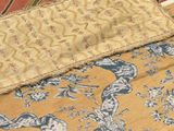 a close up of a bed with a blanket and a pillow