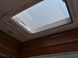 a skylight above a sink in a small bathroom