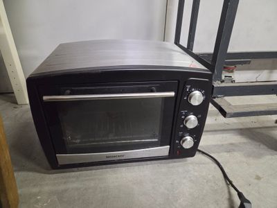 a toaster oven sitting on the floor next to a ladder