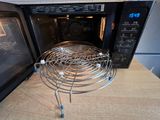 a microwave with a wire basket on top of it