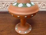 a small clay bowl with a flower on it