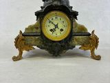 a clock that has a statue on top of it