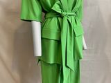 the mannequin is wearing a green suit with a belt