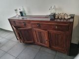 a wooden cabinet with several bottles on top of it