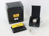 une image représentant une montre dans un coffret noir muni d'une étiquette jaune