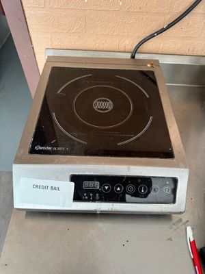 une petite cuisinière surmontée d'un brûleur noir