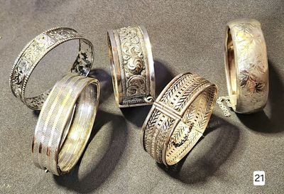 several different types of silver rings and bracelets on a table