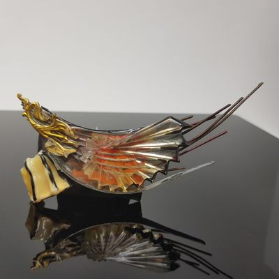 une sculpture en verre représentant un oiseau sur un fond noir