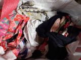 a pile of clothes in a bag on a bed
