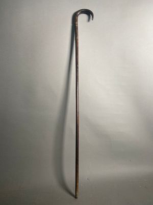 une vieille canne avec un manche en bois sur fond blanc